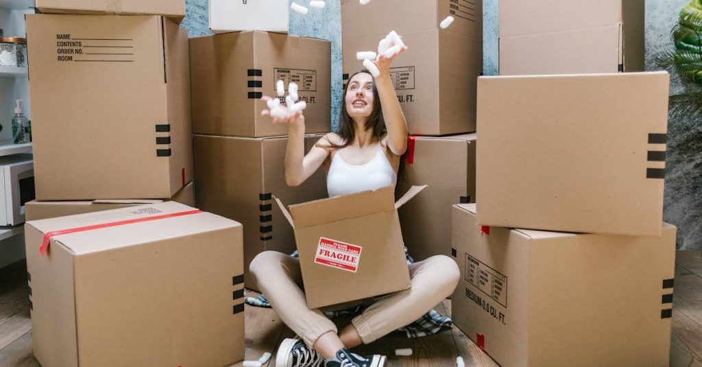 Young woman surrounded by cardboard boxes, happily moving into her new apartment.